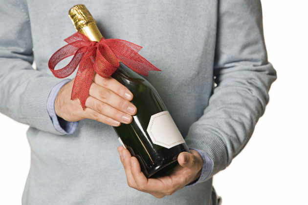 man holding bottle of champagne with a bow